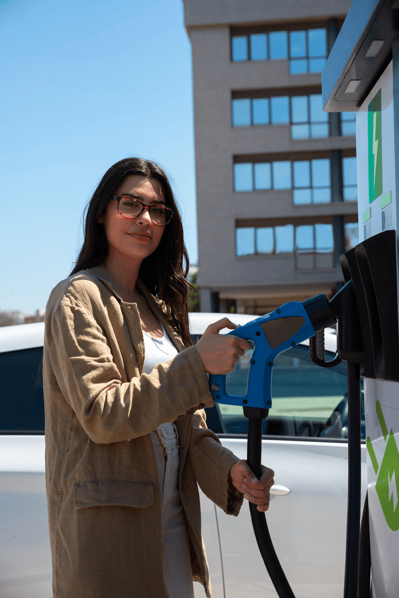 Woman charging her EV at a public DC fast charging station
